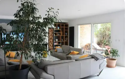 a living room with a white couch and a plant at Villa avec vue sur le pilon du roi in Aix-en-Provence
