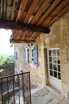a stone house with a wooden roof and a door at Les 2 voûtes - Mas provençal pour 10 personnes in Oppède