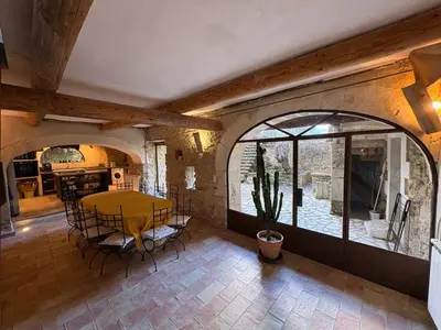 a kitchen and dining room with a table and chairs at Les 2 voûtes - Mas provençal pour 10 personnes in Oppède