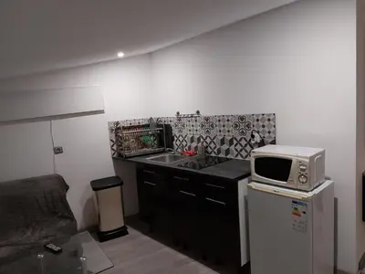 a small kitchen with a microwave and a sink at Studio à louer sur Miramas in Miramas