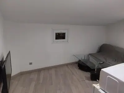 a small white room with a bed and a television at Studio à louer sur Miramas in Miramas