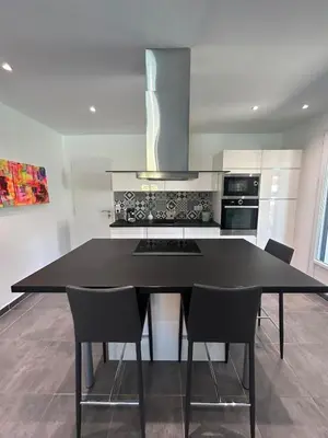 a kitchen with a black table and chairs at Villa confort avec piscine in Entraigues-sur-la-Sorgue