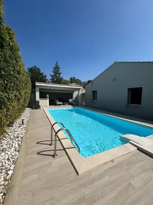 a swimming pool in the backyard of a house at Villa confort avec piscine in Entraigues-sur-la-Sorgue