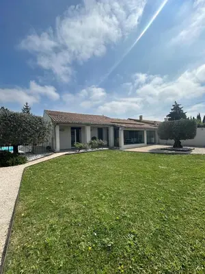 a house with a large lawn in front of it at Villa confort avec piscine in Entraigues-sur-la-Sorgue