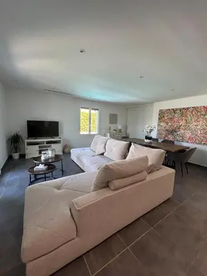 a living room with a couch and a television at Villa confort avec piscine in Entraigues-sur-la-Sorgue