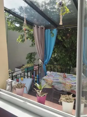 a window view of a patio with potted plants at Chez Nine, chambre indépendante avec terrasse in Sénas