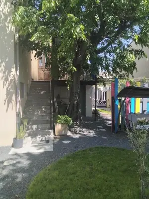 a house with stairs and a tree in a yard at Chez Nine, chambre indépendante avec terrasse in Sénas