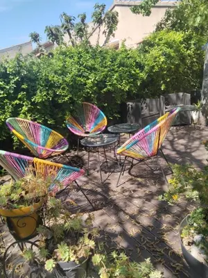 a group of chairs and tables with colorful umbrellas at Chez Nine, chambre indépendante avec terrasse in Sénas