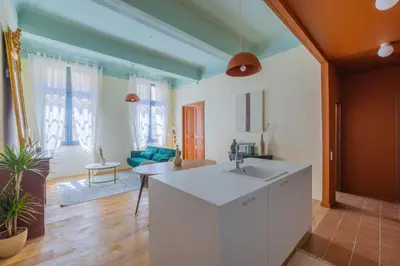 a kitchen with a sink and a living room at Appartement Belle lettre 4 in Aix-en-Provence
