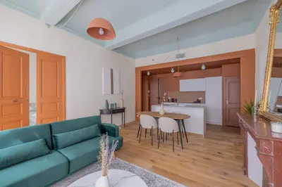 a living room with a green couch and a table at Appartement Belle lettre 4 in Aix-en-Provence