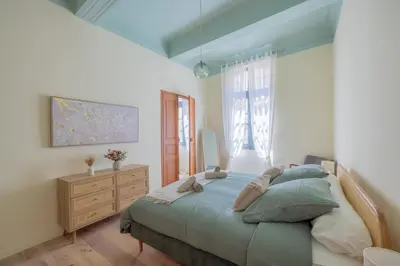 a bedroom with a bed and a dresser and a window at Appartement Belle lettre 4 in Aix-en-Provence