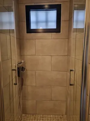 a bathroom with a shower with a window at La maison du quai in LʼIsle-sur-la-Sorgue