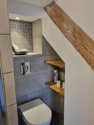 a bathroom with a toilet underneath a staircase at La maison du quai in LʼIsle-sur-la-Sorgue