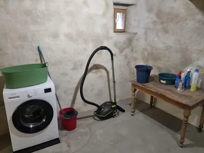 a washing machine with a vacuum next to a table at La maison du quai in LʼIsle-sur-la-Sorgue