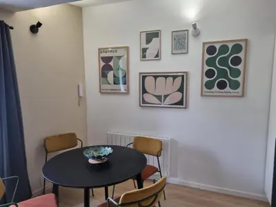 a dining room with a table and chairs at La maison du quai in LʼIsle-sur-la-Sorgue