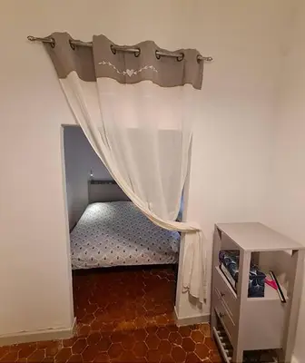 a small room with a bed with a curtain at Inactif in Aix-en-Provence