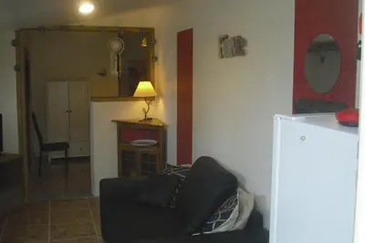 a living room with a couch and a room with a table at Lou mas li Pitchoun 