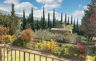 a garden with cypress trees and a fence at Baumann 1 in Bédoin