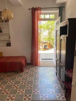a room with a bed and a door with a window at La Maison Rose I Maison de village familiale in Lagnes
