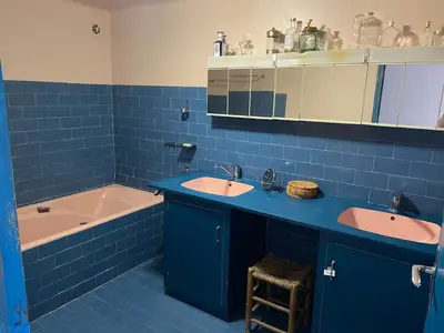 a blue tiled bathroom with two sinks and a tub at La Maison Rose I Maison de village familiale in Lagnes