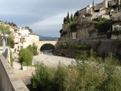 a bridge over a river next to a mountain at PROVENCE VAUCLUSE VELLERON Superbe maison avec piscine tout confort in Velleron