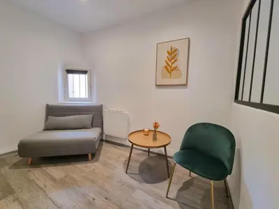 a living room with a couch and a table and a chair at Renovated 2-room apartment in historic center in Aix-en-Provence