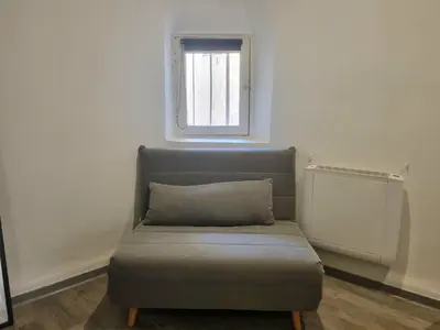 a couch sitting in a room with a window at Renovated 2-room apartment in historic center in Aix-en-Provence