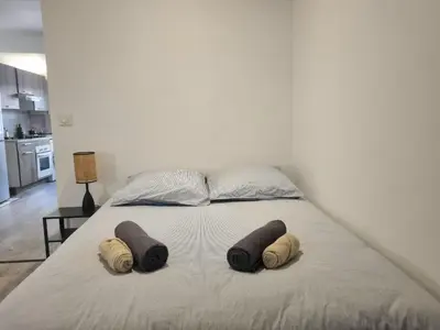 a bed with three pillows on it in a bedroom at Renovated 2-room apartment in historic center in Aix-en-Provence