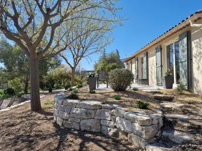 a stone retaining wall in front of a house at L'Oustalet des Vignes in Saint-Saturnin-les-Apt