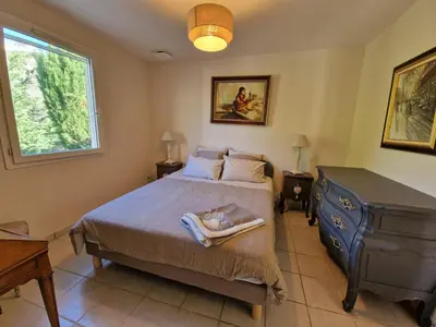 a bedroom with a bed and a dresser and a window at L'Oustalet des Vignes in Saint-Saturnin-les-Apt