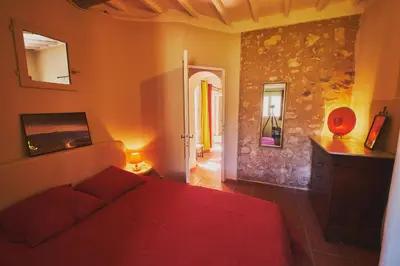 a bedroom with a red bed in a room at Maison provençale avec jardin in Velleron