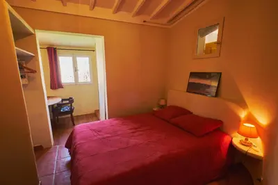 a bedroom with a red bed in a room at Maison provençale avec jardin in Velleron