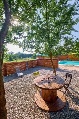 a wooden table with a tree in a yard at Maison provençale avec jardin in Velleron