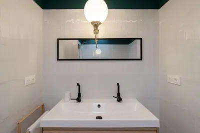 a bathroom with a white sink and a mirror at Appartement T4 plein centre ville escalier étroit in Aix-en-Provence