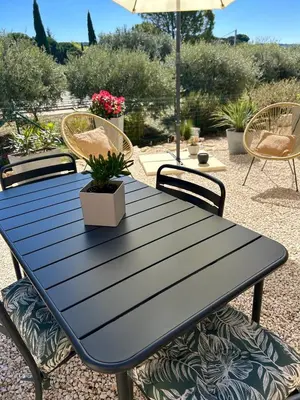 a black picnic table with chairs and an umbrella at Le Bonheur à Ventoux in Saint-Pierre-de-Vassols