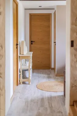 a hallway with a wooden door and a rug at Coudignac 1891 in Lagnes