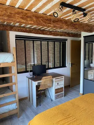 a bedroom with a desk with a computer on it at Coudignac 1891 in Lagnes