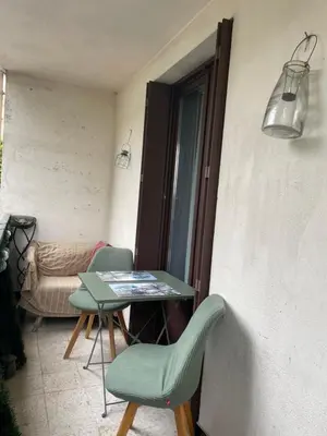 a room with a table and chairs and a window at bel appartement T3 Aix Nord in Aix-en-Provence