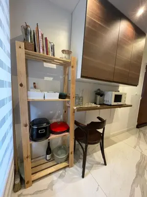 a kitchen with a book shelf and a table at bel appartement T3 Aix Nord in Aix-en-Provence