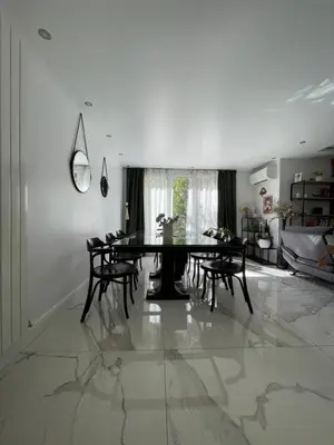 a dining room with a table and chairs on a marble floor at bel appartement T3 Aix Nord in Aix-en-Provence