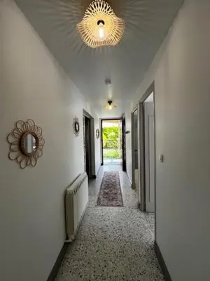 a hallway with white walls and a ceiling with a mirror at Charmant appartement rénové, à 15 mn d'Avignon et de son festival in Entraigues-sur-la-Sorgue