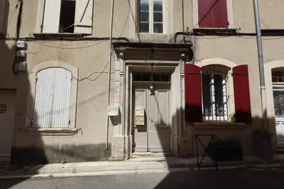a door to a building with red and white windows at Studio cozy au coeur du village - Wifi - Netflix in Monteux