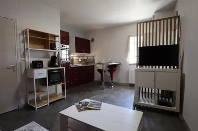 a living room with a tv and a kitchen at Studio cozy au coeur du village - Wifi - Netflix in Monteux