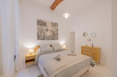a white bedroom with a bed and a yellow dresser at Appartement Belle Lettre 5 in Aix-en-Provence