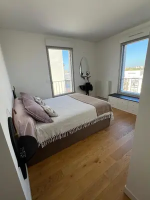 a bedroom with a large bed and two windows at Spacious Duplex with Terrace City Center in Aix-en-Provence