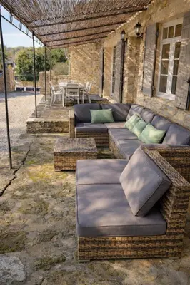 a outdoor patio with couches and a table and a table at Maison en pierre avec piscine chauffée, jacuzzi et vue sur Gordes in Gordes