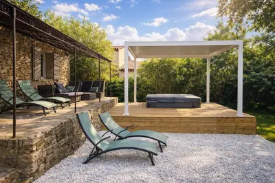 a group of chairs sitting on a wooden deck at Maison en pierre avec piscine chauffée, jacuzzi et vue sur Gordes in Gordes