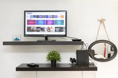 a computer monitor sitting on a black shelf at Le Mirabeau - Hypercenter studio - Wifi - Train station in Aix-en-Provence