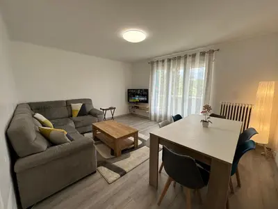 a living room with a couch and a table at Appartement Lumineux avec Balcon in Carpentras