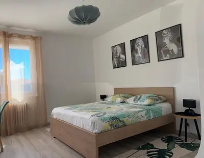 a bedroom with a bed and a table in it at Appartement Lumineux avec Balcon in Carpentras